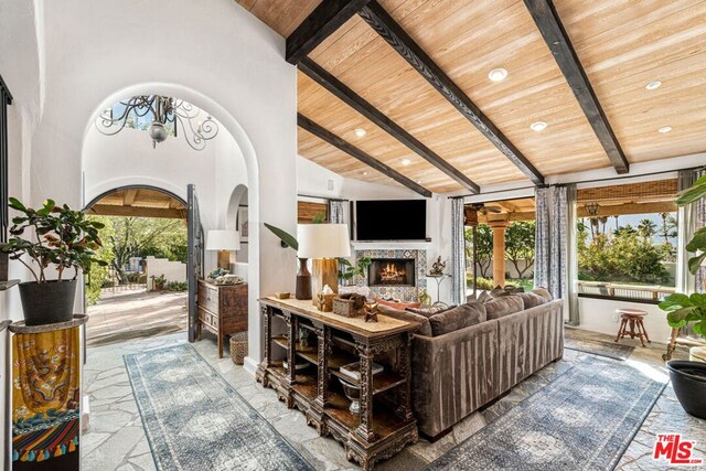 living room featuring beamed ceiling, a healthy amount of sunlight, wood ceiling, and high vaulted ceiling