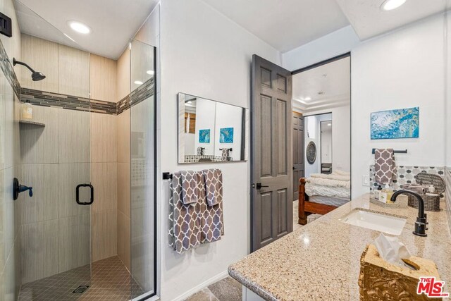 bathroom with a shower with door and vanity