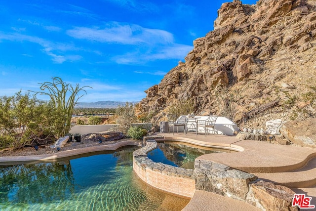 view of pool featuring a mountain view and a patio area