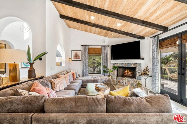 living room featuring wood ceiling, a fireplace, high vaulted ceiling, and beamed ceiling