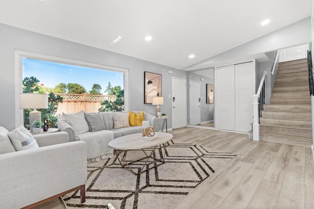 living room featuring vaulted ceiling and light wood-type flooring