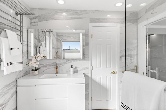 bathroom with vanity, tile walls, and walk in shower