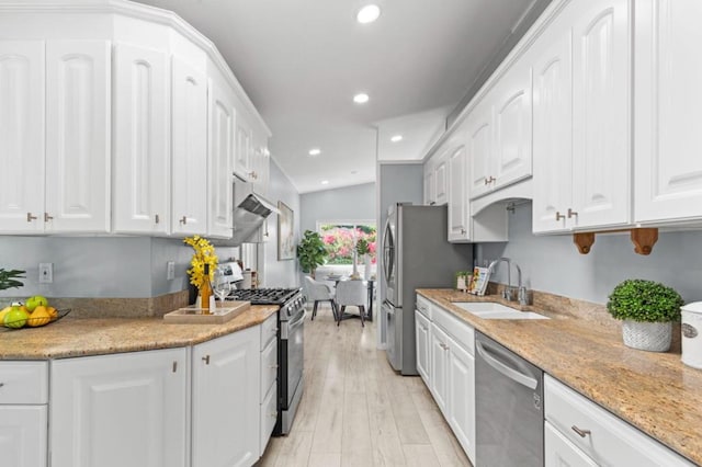 kitchen with light stone counters, sink, white cabinets, and appliances with stainless steel finishes