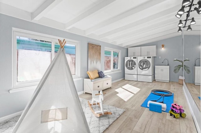 washroom featuring cabinets, light hardwood / wood-style floors, and washing machine and dryer