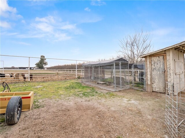 view of yard with a rural view and an outbuilding