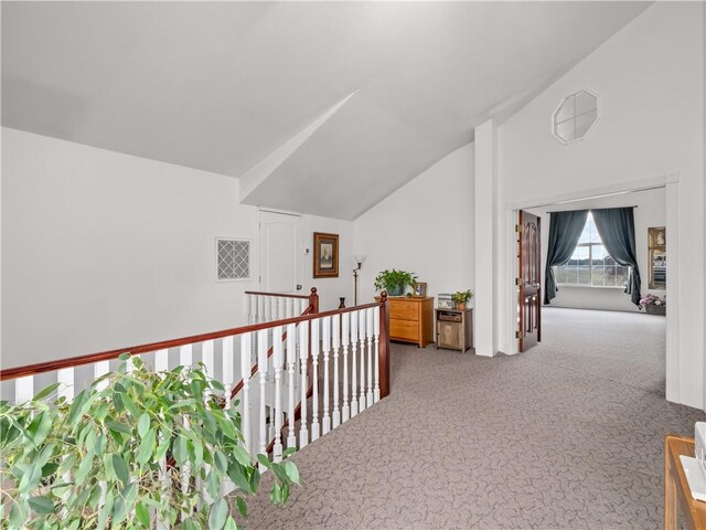 hall featuring lofted ceiling and carpet flooring