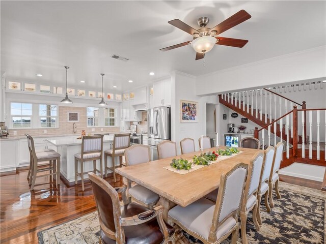 dining room featuring ornamental molding, ceiling fan, and dark hardwood / wood-style flooring