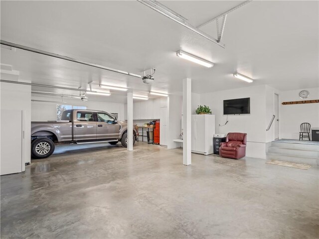 garage featuring a garage door opener and white refrigerator