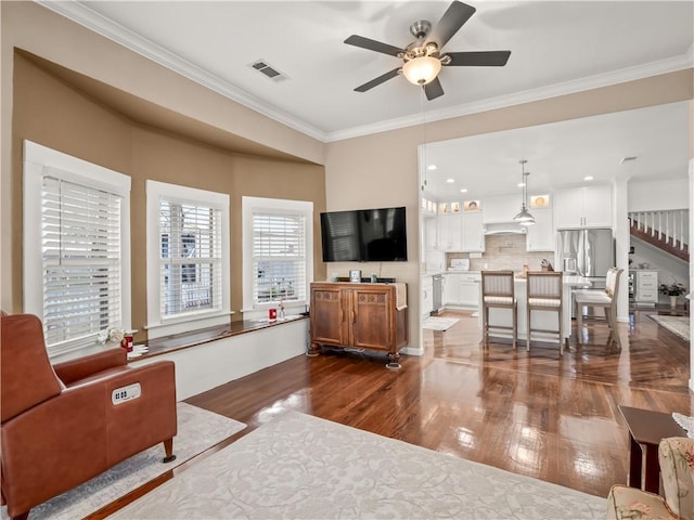 living room featuring ceiling fan, ornamental molding, and dark hardwood / wood-style flooring