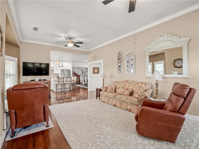 living room with ceiling fan, ornamental molding, wood-type flooring, and a wealth of natural light