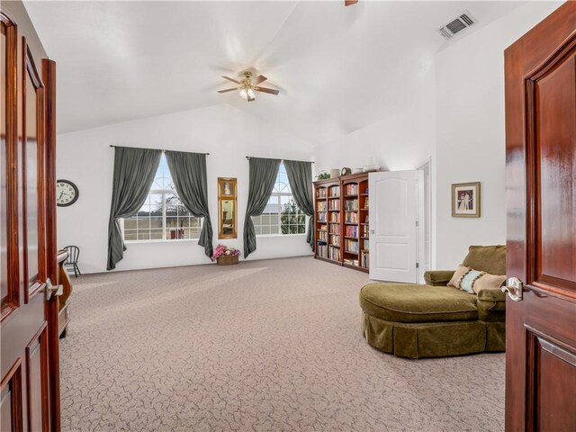 living area with light carpet, high vaulted ceiling, and ceiling fan