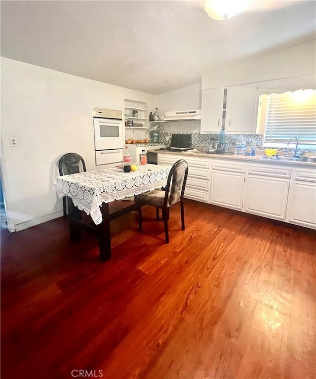 dining room with wood-type flooring, lofted ceiling, and sink