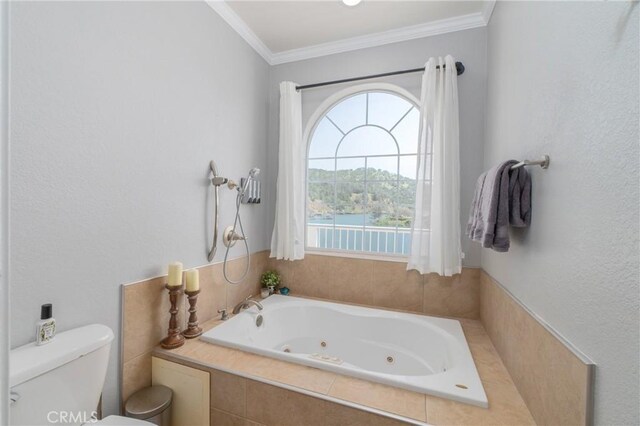 bathroom featuring ornamental molding, toilet, and tiled tub