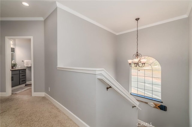 staircase featuring crown molding and an inviting chandelier