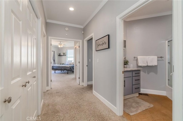 hall with crown molding and light tile patterned flooring