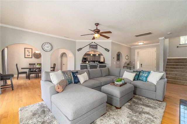 living room featuring hardwood / wood-style flooring, ornamental molding, and ceiling fan