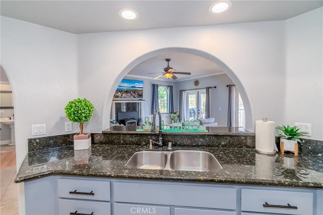 kitchen featuring sink, dark stone countertops, and ceiling fan