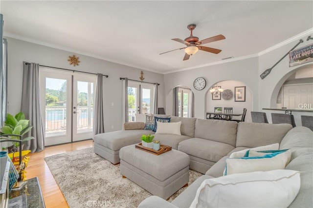 living room featuring ornamental molding, ceiling fan, light hardwood / wood-style floors, and french doors