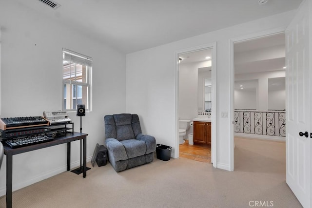 sitting room with baseboards, visible vents, and carpet