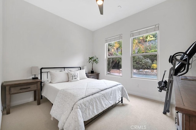 bedroom with light carpet, baseboards, and ceiling fan