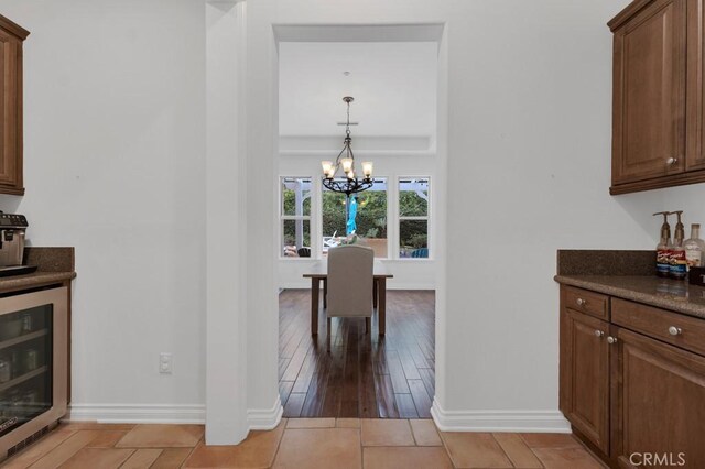 dining area featuring wine cooler and a chandelier