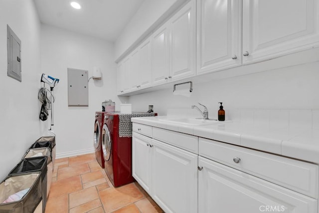 washroom featuring cabinets, washer and dryer, sink, and electric panel