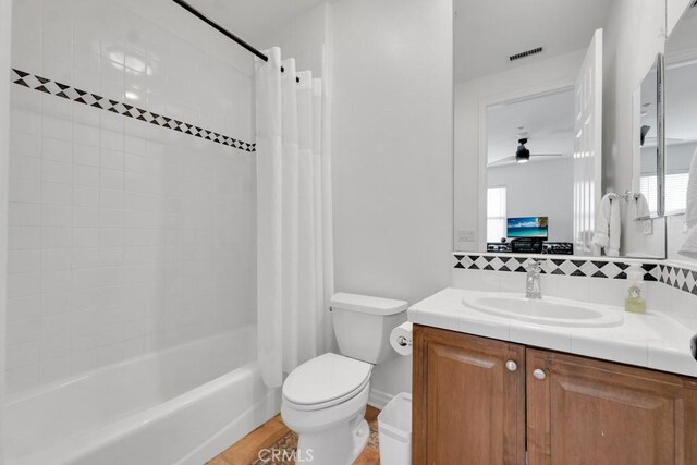 full bathroom with shower / tub combo with curtain, tasteful backsplash, vanity, ceiling fan, and toilet