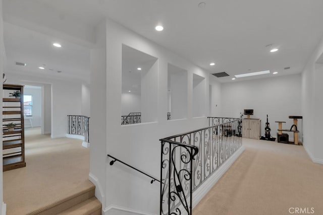 hall with carpet floors, an upstairs landing, visible vents, and recessed lighting
