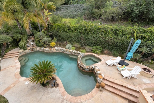 view of pool featuring a pool with connected hot tub and a patio