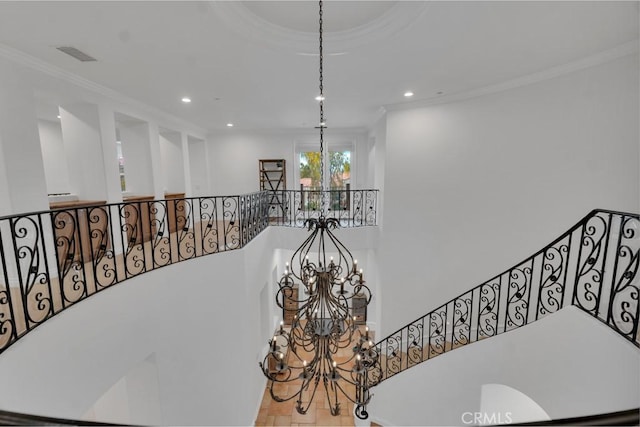 staircase featuring ornamental molding and a chandelier