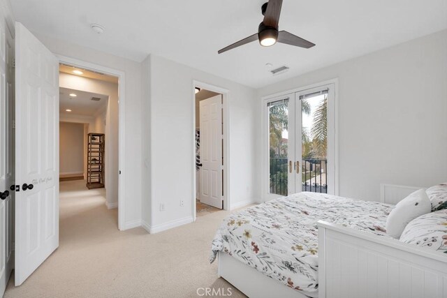 carpeted bedroom featuring french doors, a walk in closet, ceiling fan, and access to outside