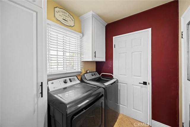 clothes washing area with cabinet space, washer and clothes dryer, and light tile patterned flooring