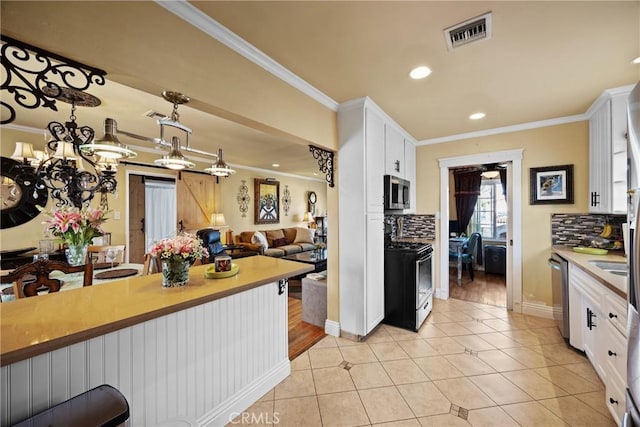 kitchen with light tile patterned floors, stainless steel appliances, visible vents, and white cabinets