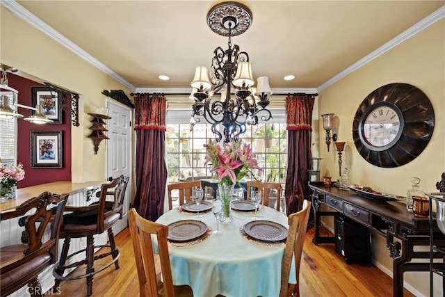 dining room featuring crown molding, recessed lighting, wood finished floors, and a notable chandelier