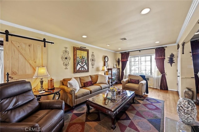 living room featuring crown molding, wood-type flooring, and a barn door