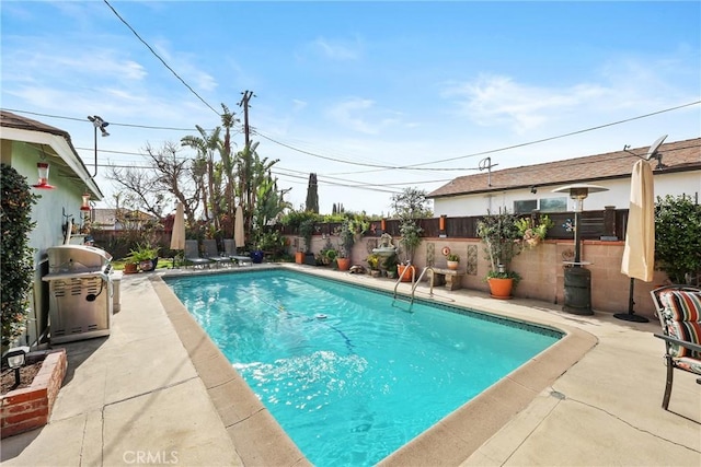 view of pool with a patio area, a fenced backyard, a grill, and a fenced in pool