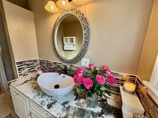 bathroom featuring tasteful backsplash and vanity