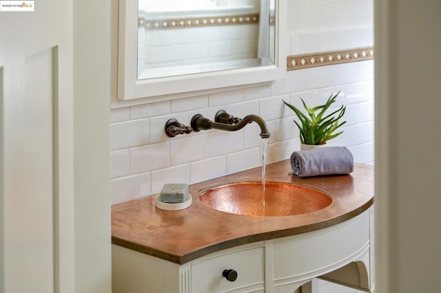 details featuring vanity and decorative backsplash