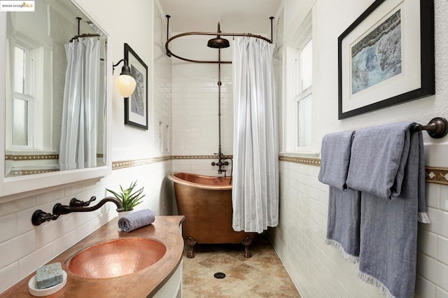 bathroom featuring tile patterned floors, curtained shower, sink, and tile walls