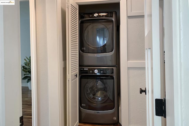 laundry area with hardwood / wood-style flooring and stacked washing maching and dryer