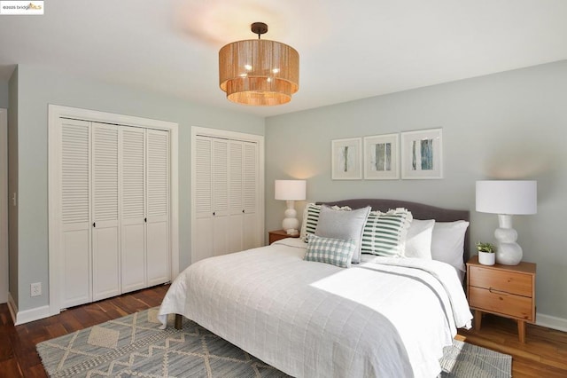 bedroom featuring dark wood-type flooring and multiple closets