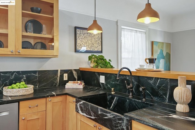 kitchen with stainless steel dishwasher, sink, hanging light fixtures, and backsplash