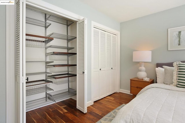 bedroom with dark wood-type flooring and a closet