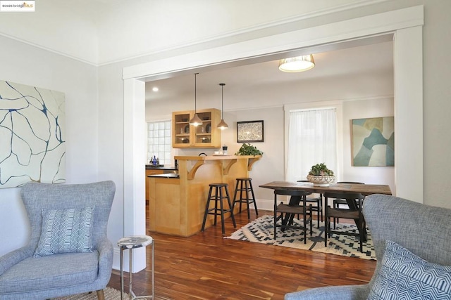 dining area featuring dark wood-type flooring and crown molding