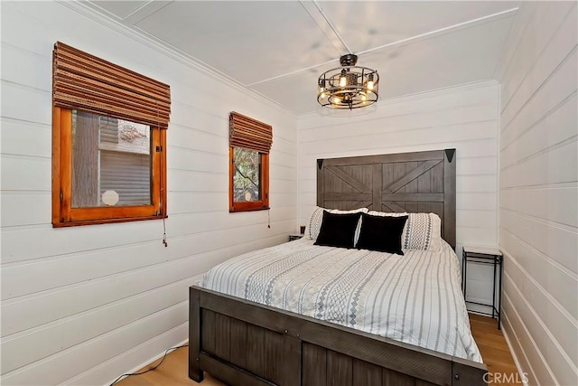 bedroom with ornamental molding and hardwood / wood-style floors