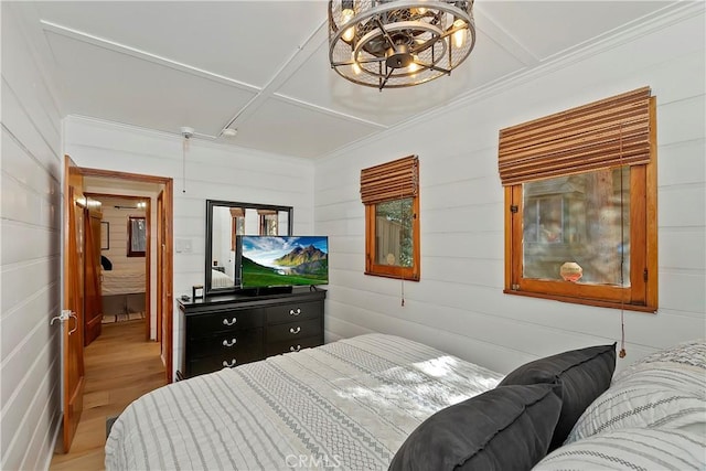 bedroom with a chandelier and light wood-type flooring