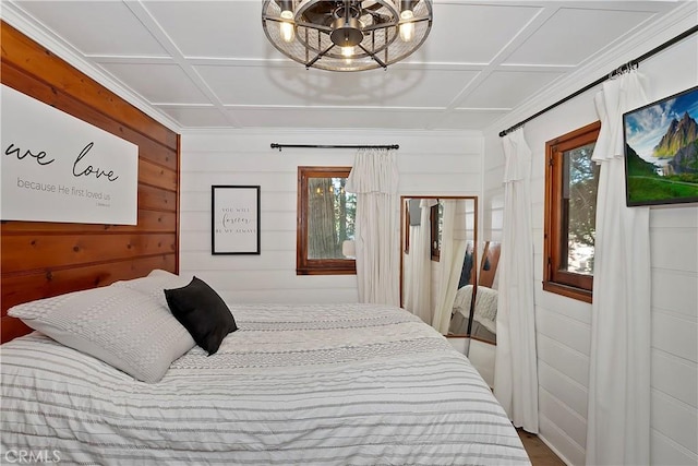 bedroom featuring coffered ceiling and a chandelier