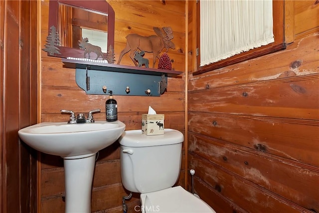 bathroom featuring toilet and wood walls