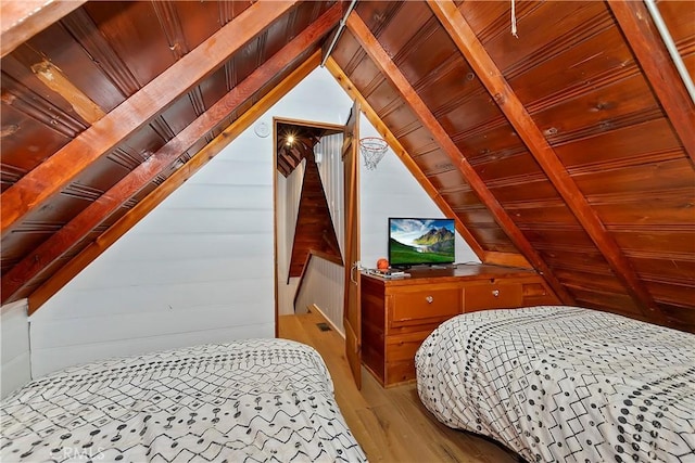 bedroom with hardwood / wood-style flooring, lofted ceiling with beams, wood ceiling, and wood walls