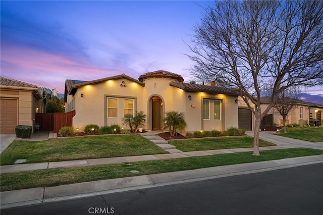 mediterranean / spanish home with a garage and a yard